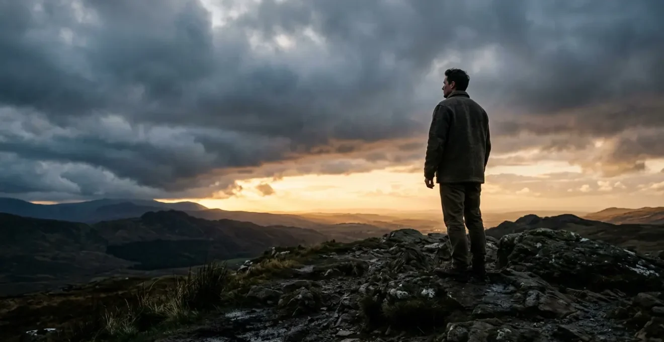 A person standing at the edge of a storm cloud looking toward distant sunlight breaking through, symbolizing realistic hope during crisis