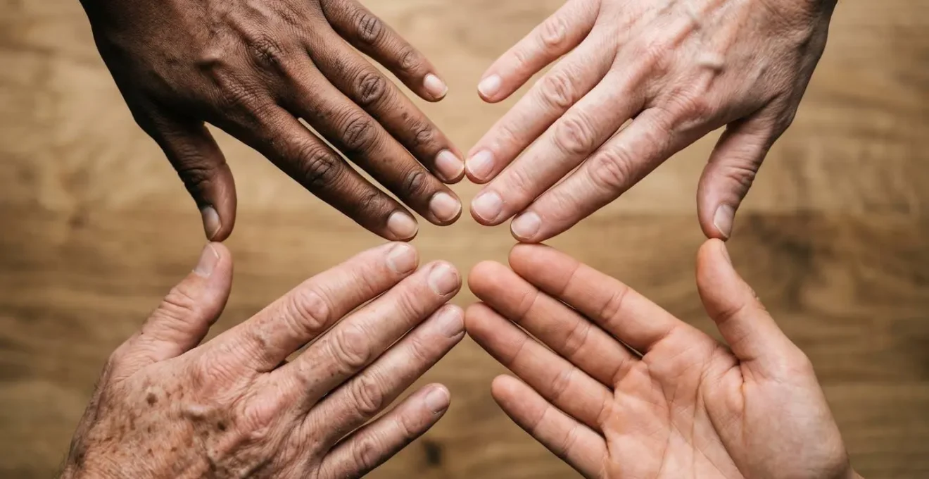 Multiple hands of diverse individuals coming together in a circle from above