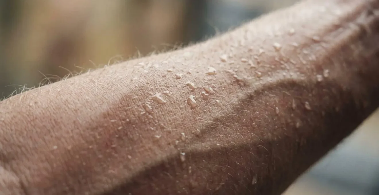 Macro close-up of water droplets on skin showing physical exertion and muscular detail