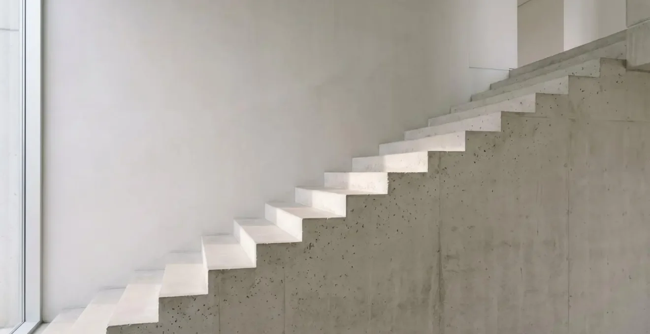 A minimalist ascending staircase bathed in natural light representing incremental progress and scaling